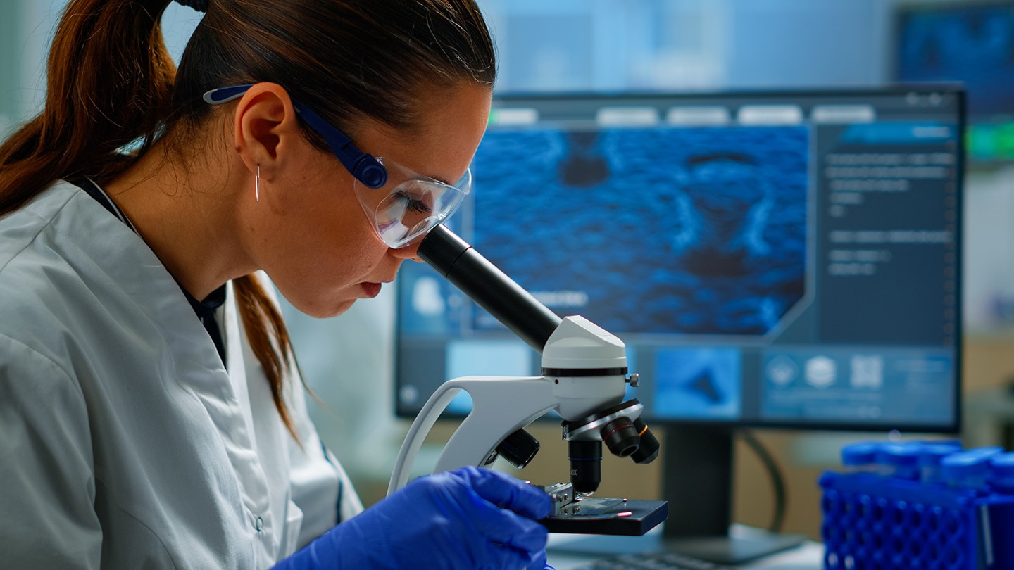 Portrait of scientist looking under microscope in medical lab, Portrait of scientist looking under microscope in medical lab